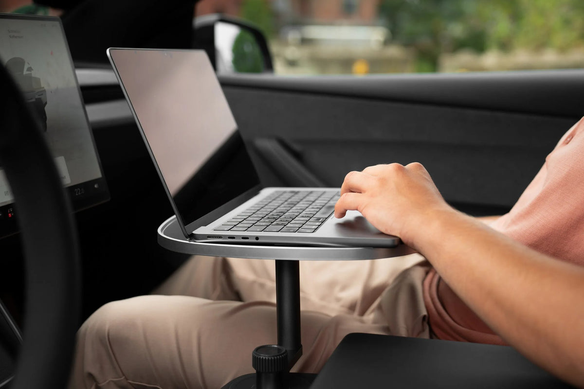 Arbeiten am Laptop auf dem weißen Cupholder-Tisch auf der Beifahrerseite