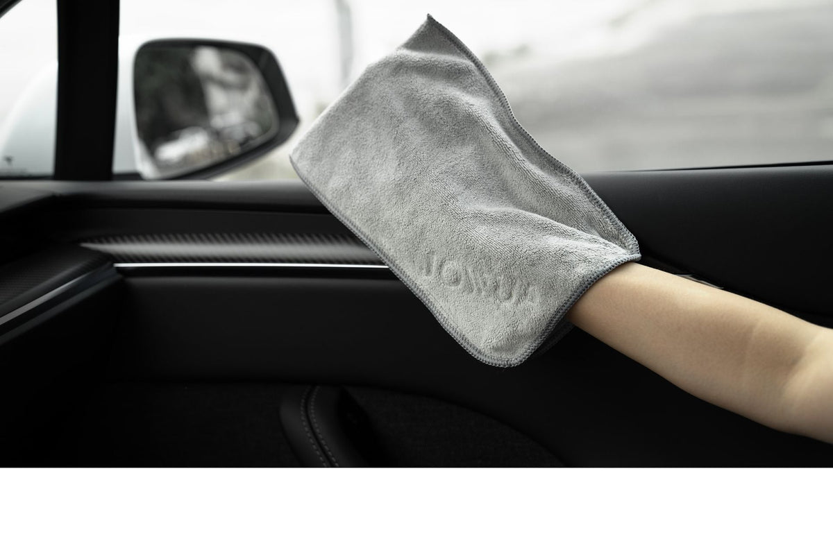 Handschuhtuch übergestreift beim Reinigen der Türverkleidung im Tesla Innenraum