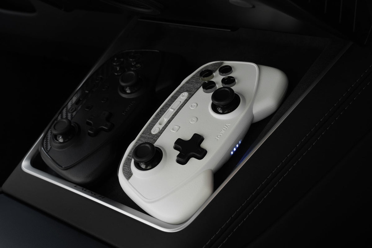 Carbon- und weißer Controller nebeneinander auf dem kabellosen Ladepad eines Tesla Model Y Juniper