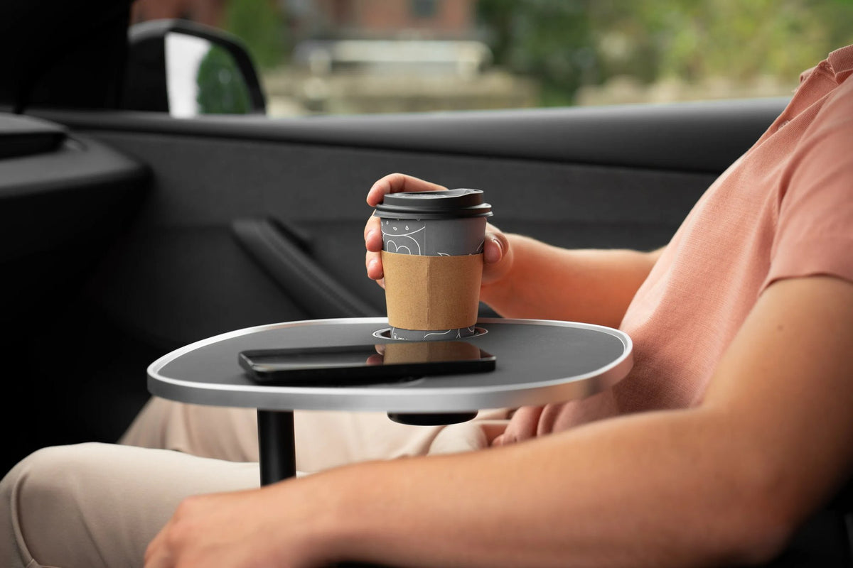 Kaffee und Smartphone auf dem schwarzen Cupholder-Tisch im Tesla